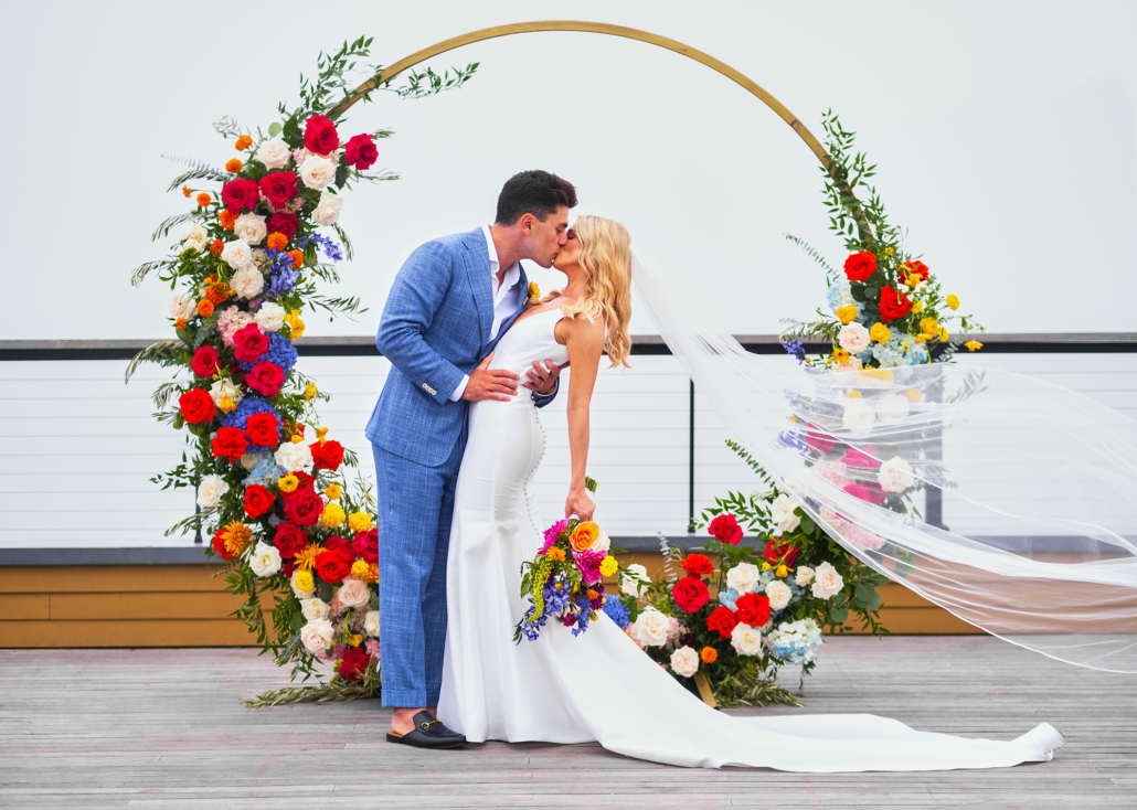 Dayna and Matthew Wedding - Bride and Groom Kissing Bouquet Moongate Flower Arch - Gurney's Montauk - Andreas and Nico