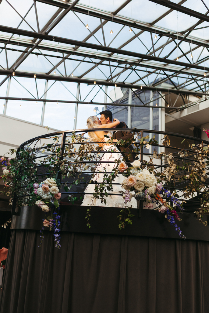 Chloe and John Wedding - Bride and Groom Kissing Staircase Floral Decor - Tribeca Rooftop - Rajotte Photography